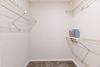 a spacious closet with two shelves and a hanging rack on the wall at 300 Riverside Apartments, Austell, GA, 30168